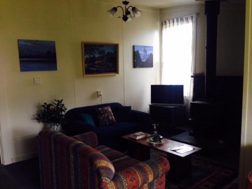 a living room with a couch and a table at Kumara Historic Cottages in Kumara
