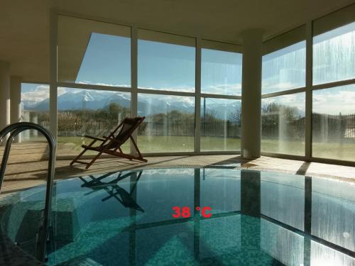 a swimming pool with a chair next to a window at Делта СПА in Banya