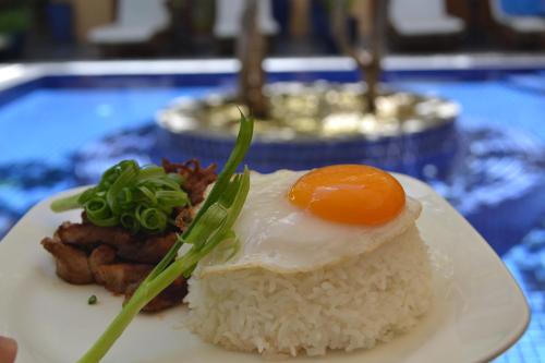 a plate of food with rice and an egg on top at House Boutique Eco Hotel in Phnom Penh