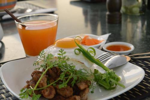 a plate of food on a table with a drink at House Boutique Eco Hotel in Phnom Penh
