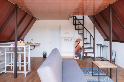 a living room with a couch and a staircase at Glamping Triangle Kusumanagara 1 in Bandung