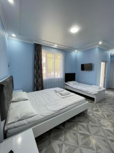 two beds in a room with blue walls at Marina kvariati in Kvariati