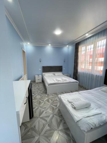 two beds in a room with blue walls at Marina kvariati in Kvariati