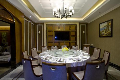 a dining room with a table and chairs and a chandelier at Shenzhen Kaili Hotel, Guomao Shopping Mall in Shenzhen