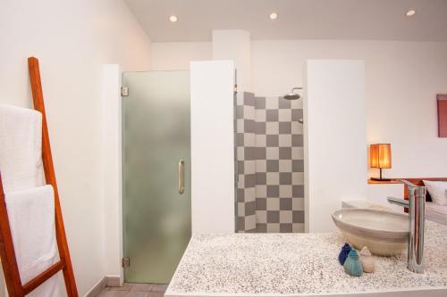 a bathroom with a glass shower with a sink at House Boutique Eco Hotel in Phnom Penh
