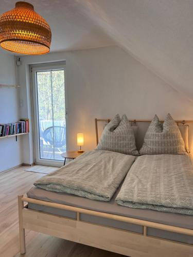 a bedroom with a large bed with a large window at Anna's Waldchalet - FeWo Waldblick in Hannoversch Münden
