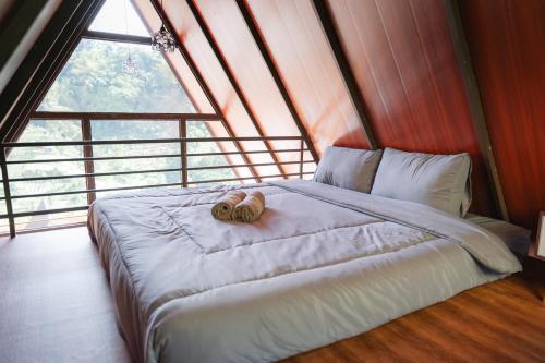 a bed in a room with a large window at Glamping Triangle Kusumanagara 1 in Bandung