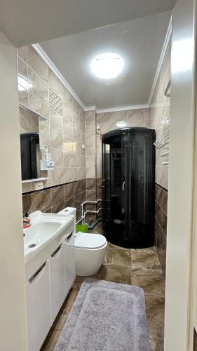a bathroom with a shower and a toilet and a sink at Гостевой дом in Tokmok