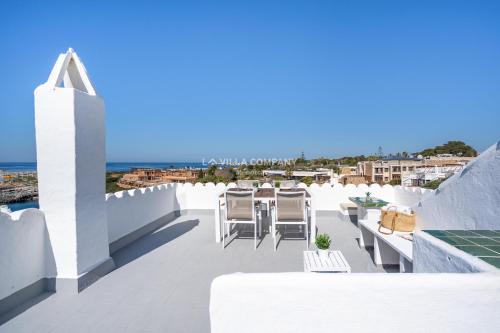 a balcony with white chairs and a view of the ocean at Apartment BINIBECA 60 in Binibeca