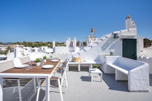 a patio with white tables and chairs on a roof at Apartment BINIBECA 60 in Binibeca