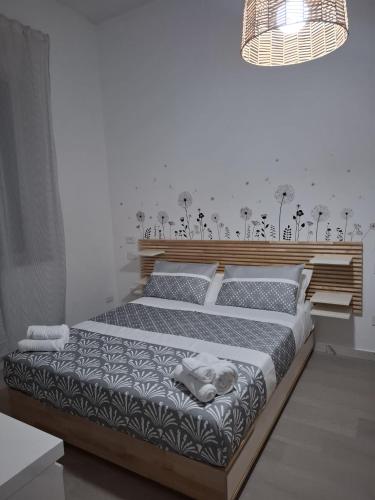 a bedroom with a large bed with a wooden headboard at Trivia Rent in Reggio di Calabria