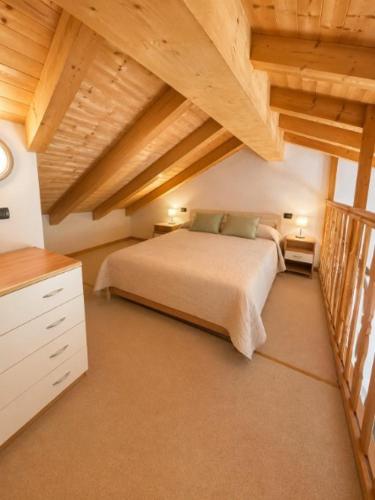 a bedroom with a bed in a room with wooden ceilings at Villa Dascia - Agenzia Cocal in Caorle