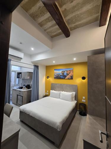 a bedroom with a bed and a yellow wall at The Shipwright's Lodge in Marsaxlokk