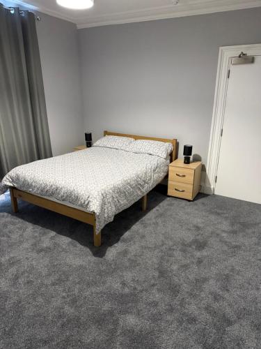 a bedroom with a bed and a night stand at St Andrew's Lettings in Peterhead