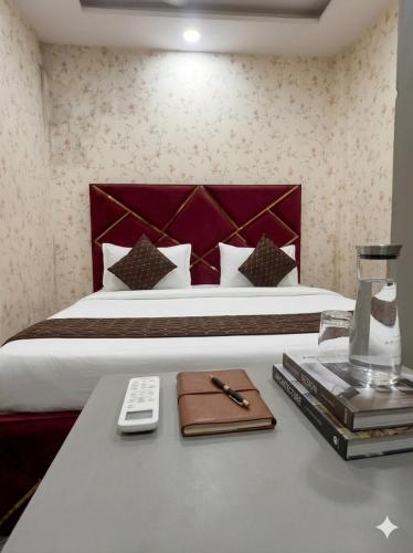 a hotel room with a bed and a table with a remote control at Cloud Cobe in New Delhi
