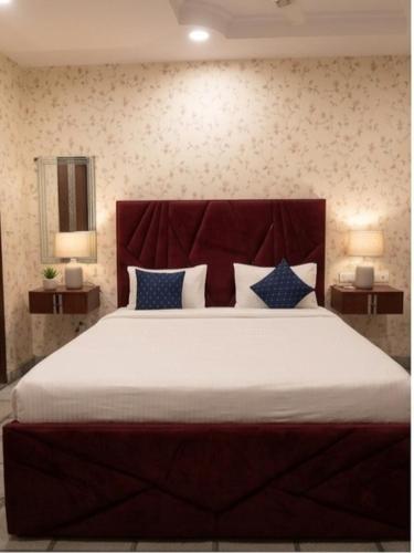 a large bed in a bedroom with two lamps at Cloud Cobe in New Delhi