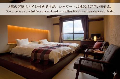 a bedroom with a large bed and a window at Hotel Hakuba Berghaus in Otari