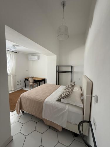 a white bedroom with a bed and a table at Casa Stinga in Capri