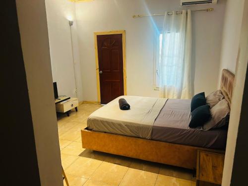 a bedroom with a bed and a television and a window at Amalis in Moroni