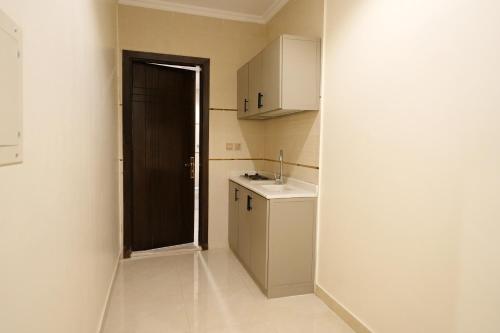 a small kitchen with a sink and a door at فندق النخبة الماسي - Diamond Elite Hotel in Medina