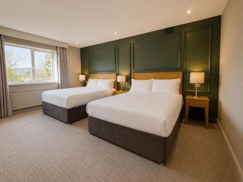 a hotel room with two beds and a window at Donegal Manor in Donegal