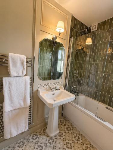 a bathroom with a sink and a mirror and a tub at Donegal Manor in Donegal