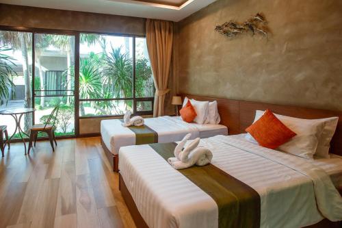 a hotel room with two beds with towels on them at Blue River Resort in Phitsanulok