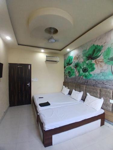 a bedroom with a bed with a painting on the wall at Agam Homestay-Two Minutes Walk From Golden Temple in Amritsar