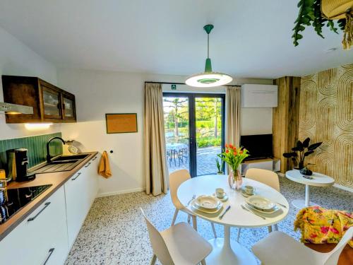 a kitchen with a table and chairs in a room at Aska Logies vakantiewoning in As
