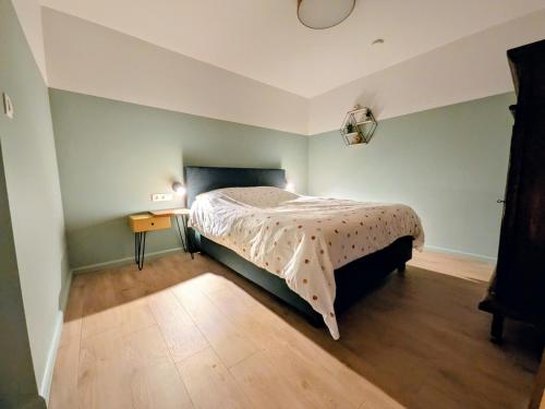 a bedroom with a bed and a wooden floor at Aska Logies vakantiewoning in As