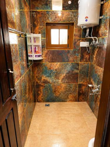 a bathroom with a tiled shower with a window at SH Valley Homestay in Srinagar