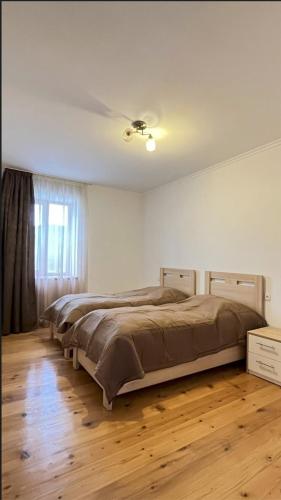 a bedroom with two beds and a ceiling fan at Nia's Guesthouse in Zemo Alvani