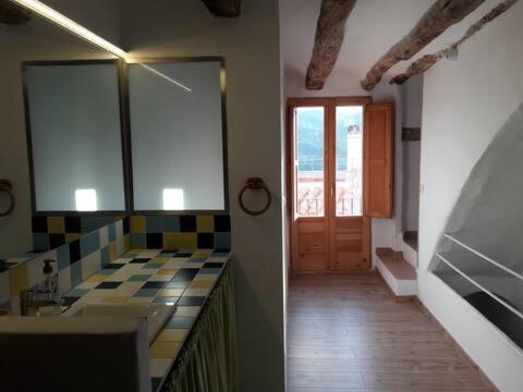 a bathroom with a counter and a door in a room at Casa cova de Benifallet in Benifallet