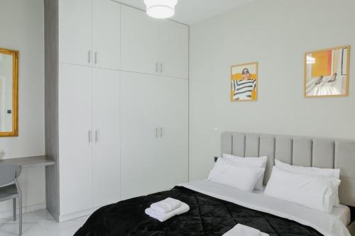 a white bedroom with a large bed with white pillows at Aphrodite Old Town Suite Xanthi in Xanthi