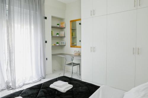 a white bedroom with a bed and a desk at Aphrodite Old Town Suite Xanthi in Xanthi