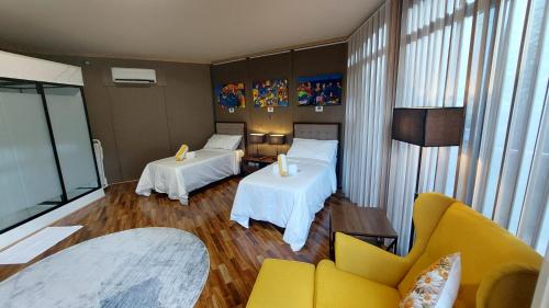 a hotel room with two beds and a couch at The Halfway Cafe-Dauin, Glamp1 - Cricket in Dauin