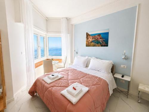 a bedroom with a large bed with two towels on it at Vertigini Suites, Il Rifugio dell Amore per SOLE COPPIE , A 50m dalla Stazione e dalla Via dell Amore con Vista Mare e Intimità Appagante in Riomaggiore