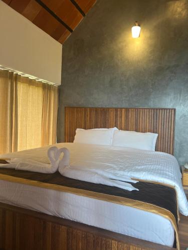 a bedroom with a large bed with white sheets at Mount Lux Villa in Devāla