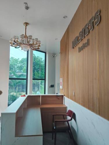 a chair in a lobby with a sign on the wall at MR SIETS hotel in Châu Xá