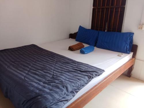 a bed in a room with blue pillows at Anna Koh Rong in Kaôh Rŭng (3)