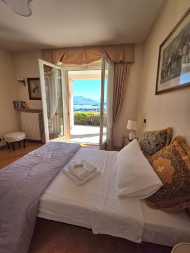 a bedroom with a large white bed with a view at Queen Apartment - Stunning Panoramic Island View in Baveno