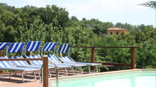 a group of chairs sitting next to a swimming pool at Appartamenti Residence Montebello, relax con giardino e piscina in Bolano