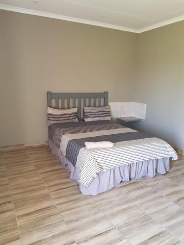 a bedroom with a bed with striped blankets and pillows at Bredell Motel in Bredell