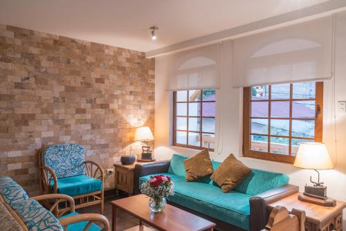 a living room with a green couch and two chairs at Casa del Balcon in Baños