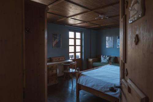 a bedroom with blue walls and a bed and a desk at Superseegarten in Bad Wiessee