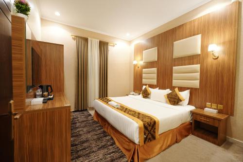 a hotel room with a bed and a television at شقق اللؤلؤة الذهبي - Golden Pearl Apartments in Sīdī Ḩamzah