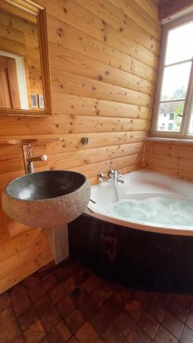 a wooden bathroom with a tub and a sink at Landhaus Danner in Goldwörth