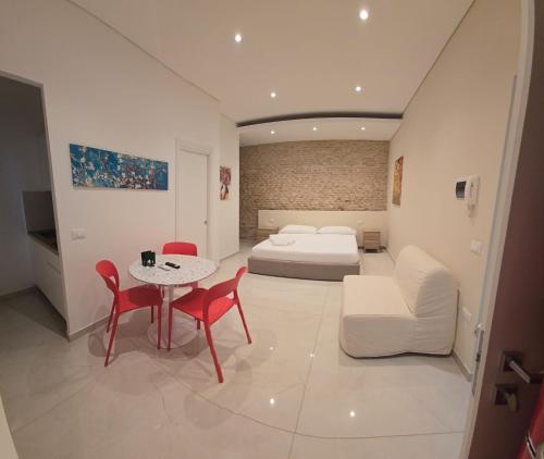 a bedroom with a bed and a table and chairs at Althea B&B in Schiavonea