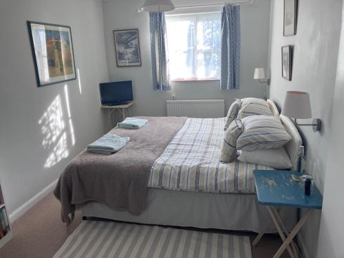 ein Schlafzimmer mit einem Bett und einem blauen Tisch in der Unterkunft Snipe Vineyard Cottage in Woodbridge
