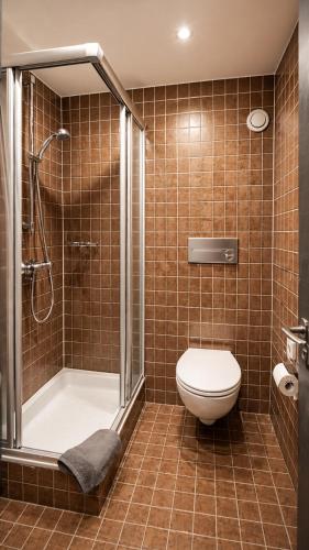 a bathroom with a shower and a toilet and a shower at BaB Hotels and Apartments-Zum Letzten G'Stehr in Bad Rippoldsau